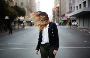 woman with long hair standing on road
