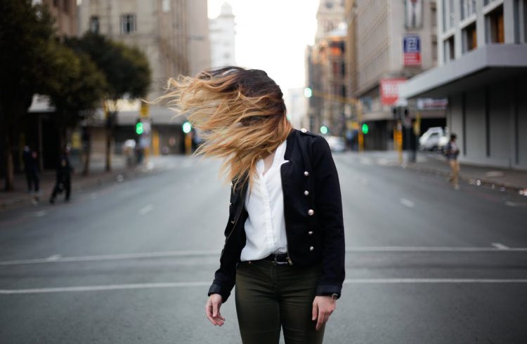 woman with long hair standing on road